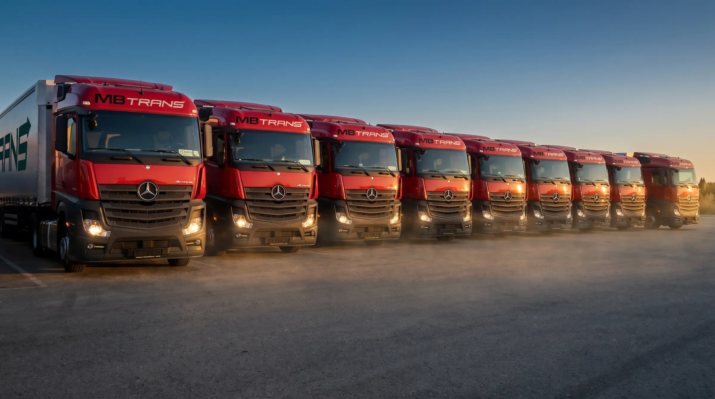 Red crvenih Mercedes-Benz Actros tegljača MB TRANS u sumrak